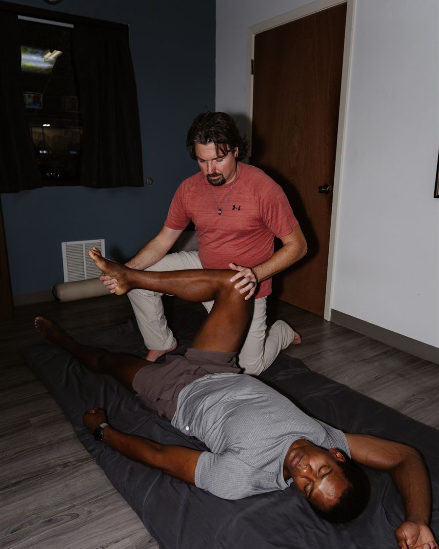 Clayton Davis guiding a client through an assisted hamstring stretch at Spa City Stretch in Hot Springs